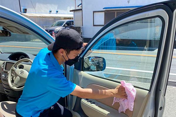 男性が車のドアを拭いている様子